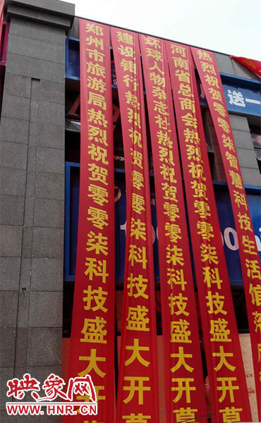 路邊一棟樓上懸掛著二三十條紅色條幅，全部是祝賀一家公司開業(yè)的。