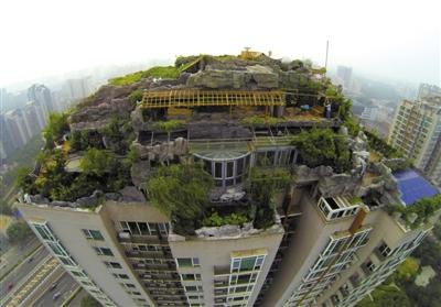 　　昨日，身穿橘黃色馬甲的工作人員在人濟(jì)山莊樓頂拆除違章建筑。新京報(bào)記者 吳江 攝