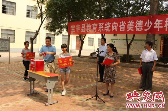 寶豐縣教育系統(tǒng)全體人員在石橋鎮(zhèn)中學(xué)為“美德少年”楊冠明同學(xué)捐款。