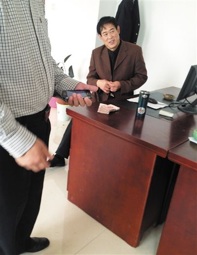 10月29日，獻(xiàn)縣國稅局稽查局辦公室內(nèi)，一名企業(yè)主交了兩萬元現(xiàn)金在桌上。新京報(bào)記者 孟祥超 攝