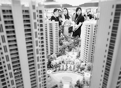 圖為近日，浙江杭州一家房產(chǎn)公司的兩位銷售人員一起向購房者介紹樓盤。新華社記者 王定昶攝