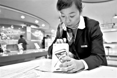 11月6日，北京移動(dòng)西直門營業(yè)廳的工作人員在為顧客購買的4G手機(jī)登記。新華社發(fā)