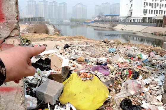金水河長江路橋下河水發(fā)臭，水邊堆放眾多垃圾