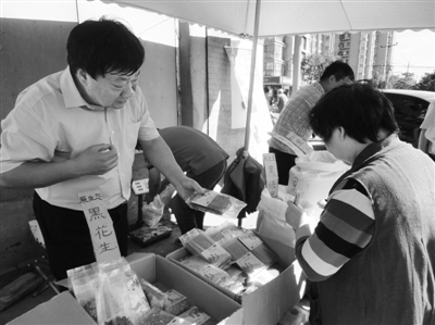 昨日，河南企業(yè)家劉春喜在京“練攤”，為顧客挑選綠豆。新京報(bào)記者 張玉學(xué) 攝