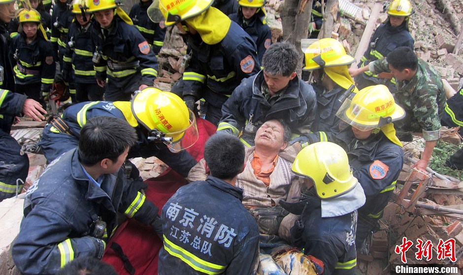 圖為南京消防隊員從廢墟中將傷者抬出。中新社發(fā) 梅亮 攝