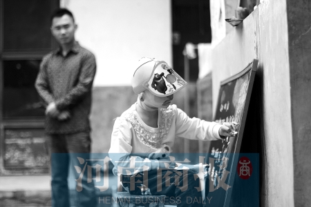 右手受傷了，她用左手在家里的小黑板上練習寫字