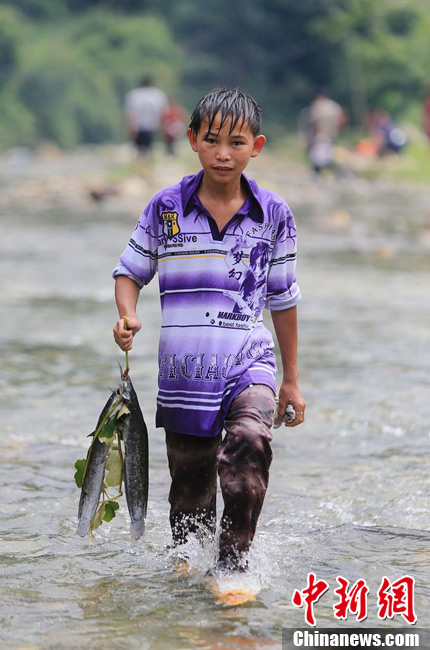 圖為7月9日，一名男孩在鬧魚(yú)節(jié)活動(dòng)中抓到了兩條魚(yú)。譚凱興 攝