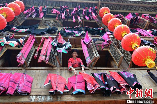 圖為紅瑤姑娘把紅衣晾曬出來(lái)。中新社發(fā) 韋吉陽(yáng) 攝