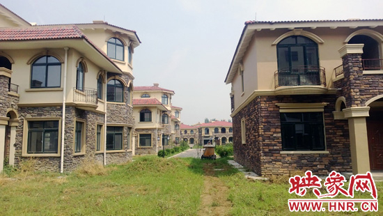 圖為別墅群內(nèi)正在進行最后的鋪路、綠化