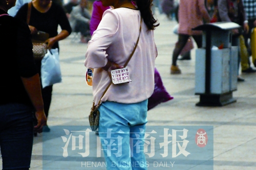 火車站廣場(chǎng)，一女子拿著寫有不同房型價(jià)位的卡片在拉客，不少市民抱怨，受過(guò)此類“騷擾”