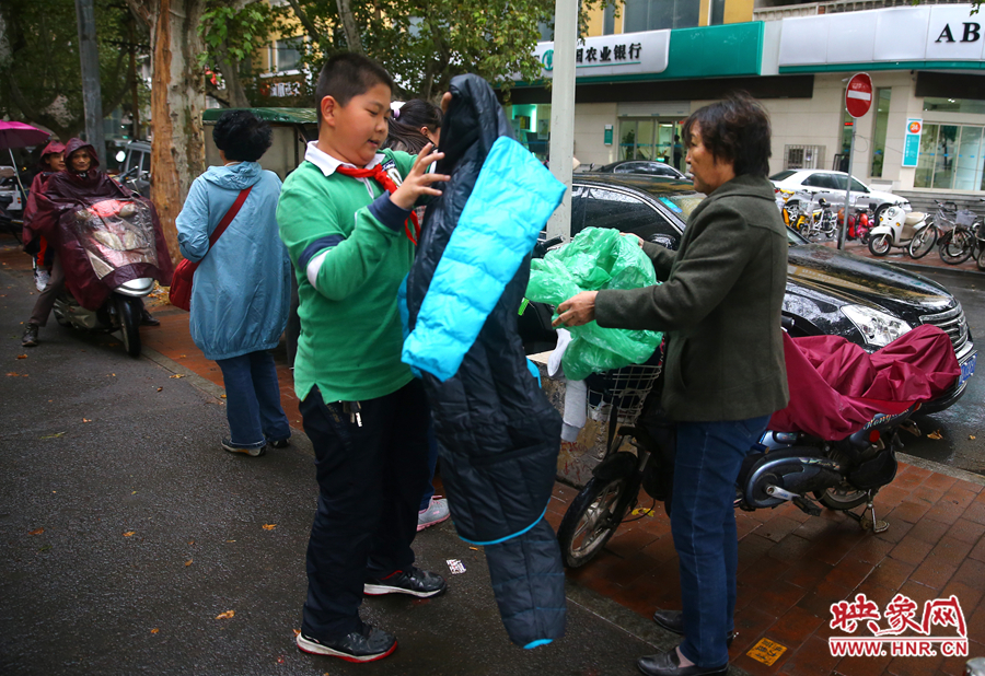 學(xué)校門口，家長給孩子帶來了御寒的厚衣服。