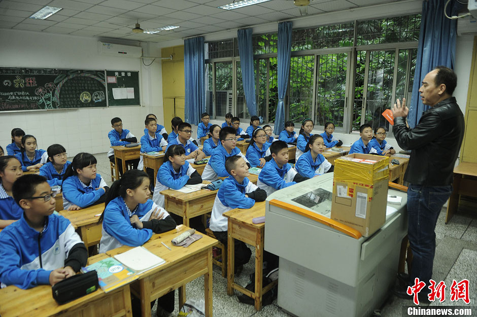 圖為老師正在向同學們講解用非智能手機對他們的好處。