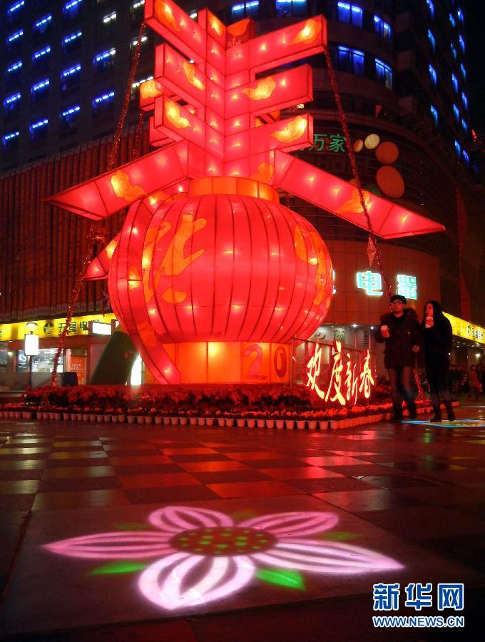 　1月30日晚，市民從蘇州市石路銀河廣場上大型“春”字彩燈景觀旁經(jīng)過。