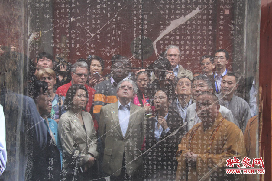 在一塊石碑前，少林寺方丈正在講解