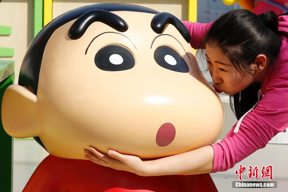 4月22日，游客與蠟筆小新合影?！跋灩P小新25周年紀(jì)念特展”日前在北京開(kāi)展，吸引了不少市民游客。