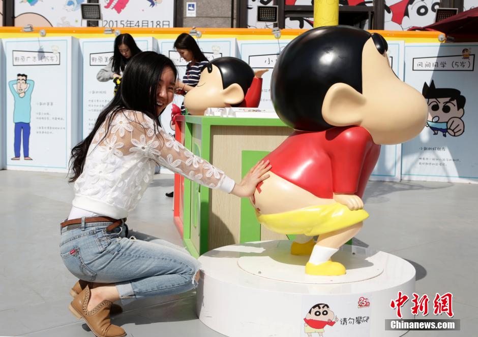 4月22日，游客與蠟筆小新合影?！跋灩P小新25周年紀(jì)念特展”日前在北京開(kāi)展，吸引了不少市民游客。