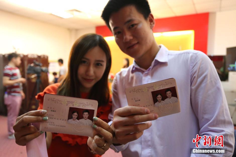 5月20日,河南鄭州,一對(duì)準(zhǔn)新人領(lǐng)完結(jié)婚證后秀自拍。