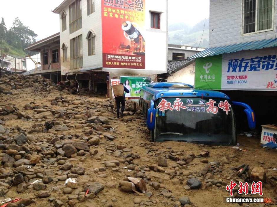 圖為山洪泥石流導(dǎo)沖進鄉(xiāng)鎮(zhèn)街道，導(dǎo)致客車被埋。