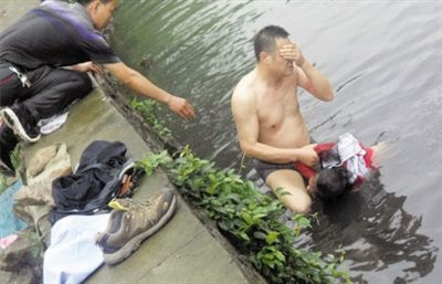 網(wǎng)友貼出民警張光聰一出河水就睜不開眼，用手抹去臉上臟水的照片。