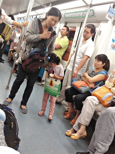 6月27日，舒馨帶一女孩在地鐵十號(hào)線行乞。她因被疑帶多個(gè)不同小孩乞討被警方搜尋。新京報(bào)記者 申志民 攝
