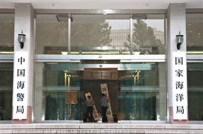 昨日，中國海警局掛牌成立。原國家海洋局和中國海監(jiān)總隊的牌匾被摘下，國家海洋局和中國海警局的新牌匾換上。黃冉 攝