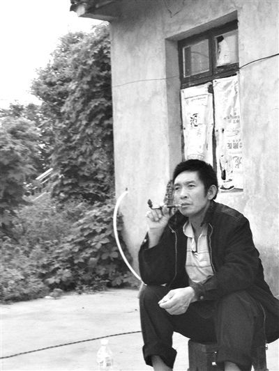 9月12日，陳文才在自己的出租屋旁抽煙。新京報(bào)記者 朱柳笛 攝