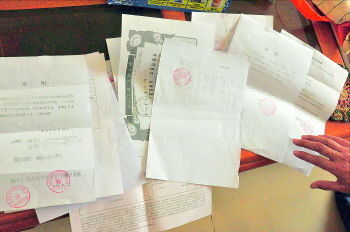 60歲的市民仇先生為了辦理公證所需的這些證明材料,半個(gè)月時(shí)間里跑了30多趟腿。記者　李萌博　攝