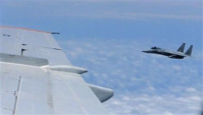 國防部網(wǎng)站12日公布的視頻截圖,日本F-15軍機從中國圖-154機頭方向危險切入,兩者最近距離約30米左右。