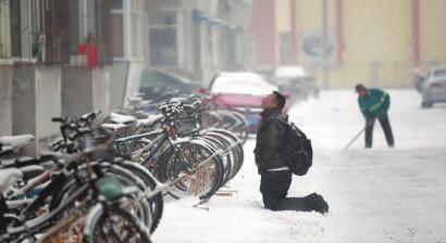 小伙子跪在樓前，一直抬頭看著樓上。 孫立國/攝