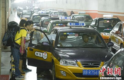 市民在北京西客站出租車候車點(diǎn)準(zhǔn)備乘車。中新社發(fā) 侯宇 攝