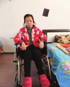 陳慶霞坐在輪椅上。她現(xiàn)在下身癱瘓，疾病纏身，生活不能自理。