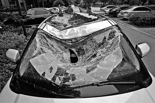 越野車車蓋以及前擋風玻璃被砸得凹陷進去。見習記者姚卡/攝