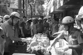 7月11日，瀏陽市北正中路，執(zhí)法人員暫扣張海的水果。這是瀏陽市城管局拍攝的執(zhí)法現(xiàn)場圖。