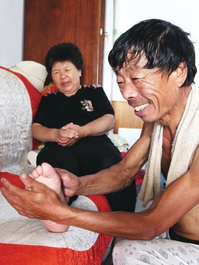 慈成富為老伴按摩。