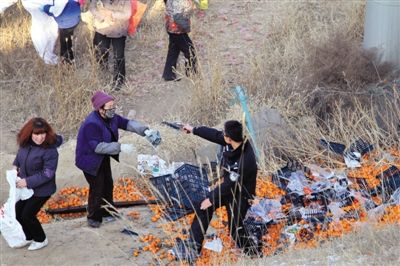 1月4日，連霍高速蘭州市榆中縣和平鎮(zhèn)段，一名警察舉著槍驅(qū)散哄搶橘子的村民。圖/CFP