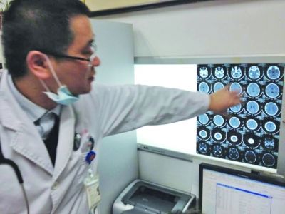 醫(yī)生在查看男孩的腦部CT片。薛馬義 攝