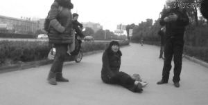 鄭大姐坐在地上，警方趕到進行施救。（視頻截圖由警方提供）