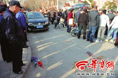 車禍現(xiàn)場的血跡被人用土覆蓋，旁邊則放著紅領巾、一雙童鞋和一頂帽子 本報記者 趙彬 攝