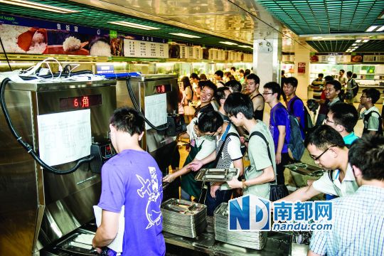 昨日，華南理工大學(xué)一食堂內(nèi)，學(xué)生們正在使用新安裝的自動打飯機打飯。中新社發(fā)