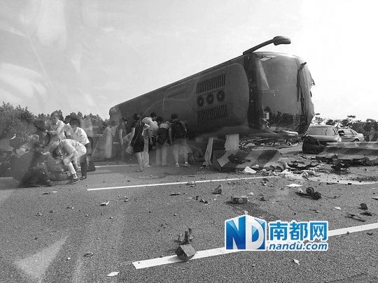 現(xiàn)場大客車側(cè)翻，玻璃碎落一地，車身卡在路邊水泥護(hù)欄上。 目擊者供圖