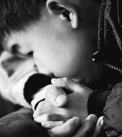 10歲小兒子緊緊握著哥哥的手。資料圖片