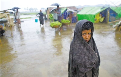 5月14日，緬甸若開邦實(shí)兌難民營，羅興亞族難民在雨中行走。熱帶風(fēng)暴“馬哈森”即將登陸緬甸，這里的難民開始乘船撤離。