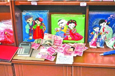 　　2012年6月21日，在朝鮮羅先特別市的一家商店里，柜臺上散落著一些人民幣。在朝鮮，人民幣比本國