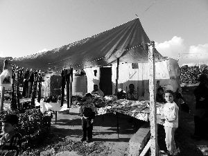 黎巴嫩一敘利亞難民營，難民支起攤鋪賣衣服掙錢。