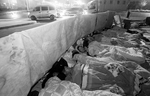 在寒冷的冬夜，為了能省點錢，方便接活，民工們仍睡在橋下。