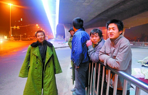 冬夜里，農(nóng)民工在橋下等著干活兒。