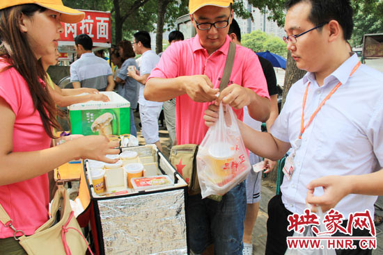 圖為徐貴雨和一名勤工助學(xué)的學(xué)生在街頭義賣快餐。