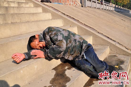這名男子的衣服以及褲子全濕透了，水從衣褲里流出來，嘴里散發(fā)著濃烈的酒氣。