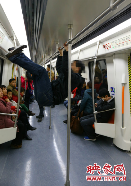 地鐵試乘日，一男子在車廂內(nèi)攀爬扶手自娛自樂
