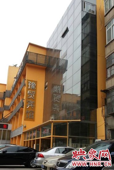 該酒店為加蓋樓層統(tǒng)一安裝上黑色玻璃，從前面看不出加蓋的痕跡